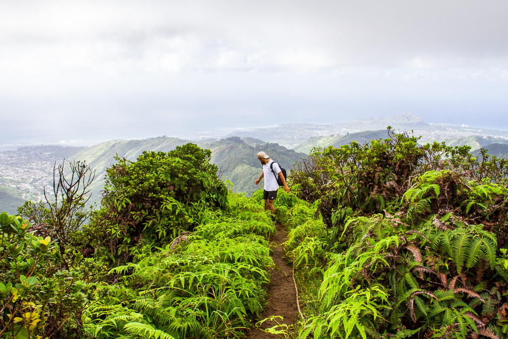 a man walking up a steep path in the mountains.