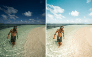 a man standing in the ocean next to a sandy beach.