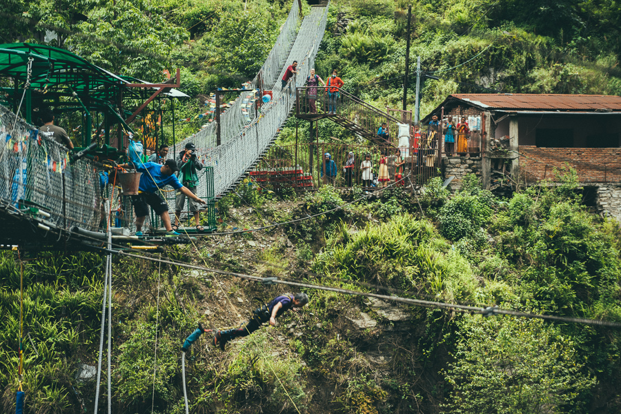 a group of people on a suspension bridge.