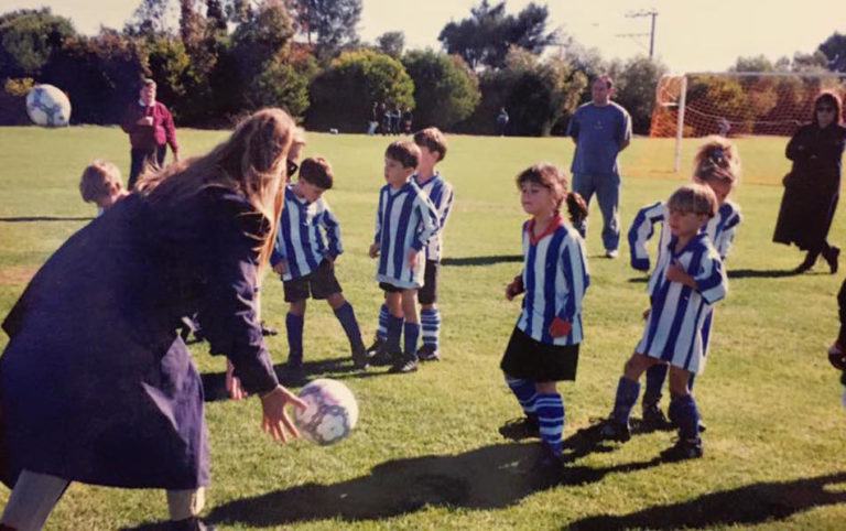 a group of young children playing a game of soccer.