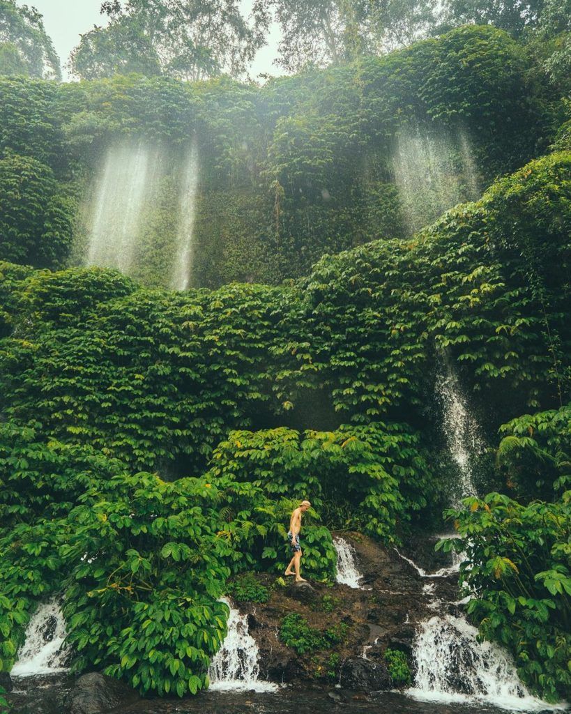 a person standing in front of a waterfall.