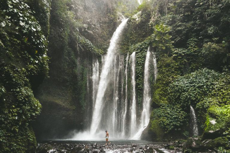 a person standing in front of a waterfall.