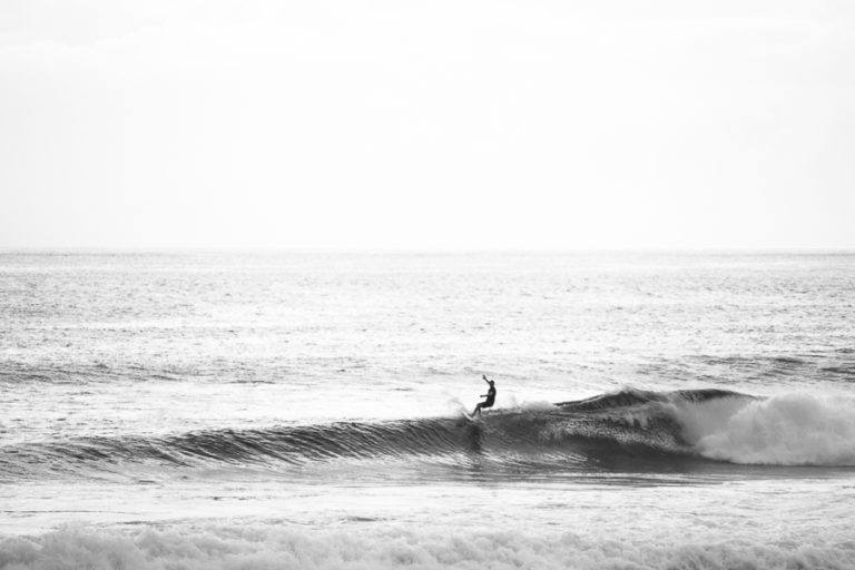 a man riding a wave on top of a surfboard.