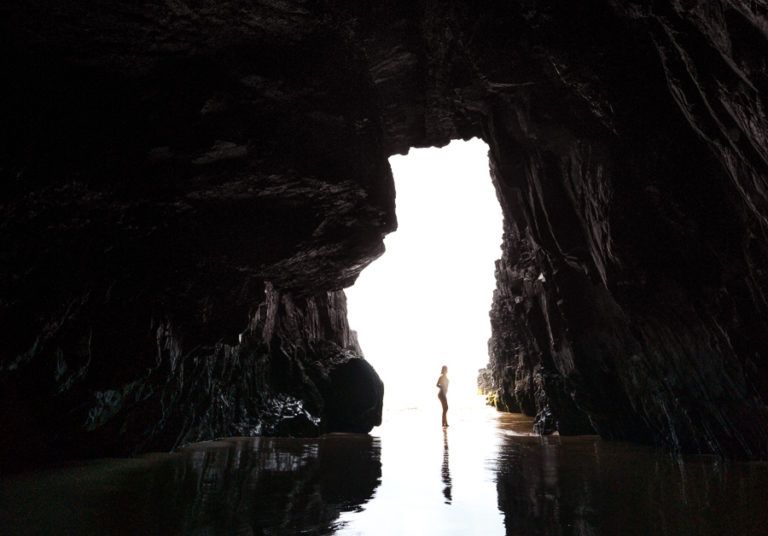 a person standing in the middle of a cave.