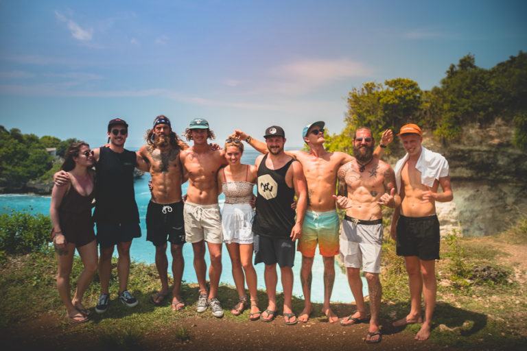 a group of men standing next to each other near a body of water.