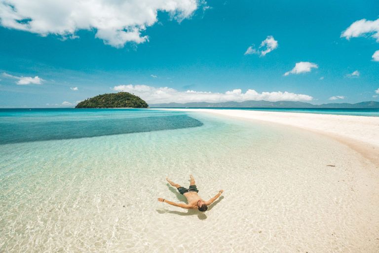 a person laying in the water on a beach.