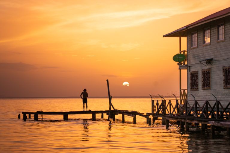 a man standing on a dock in front of a house.