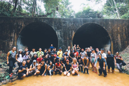 a group of people standing in front of a tunnel.