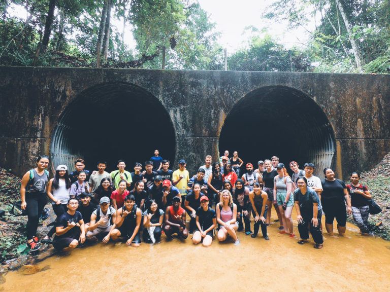 a group of people standing in front of a tunnel.
