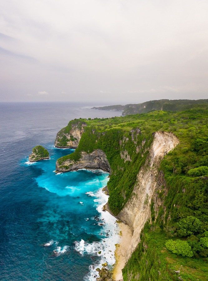 an aerial view of a cliff and a body of water.