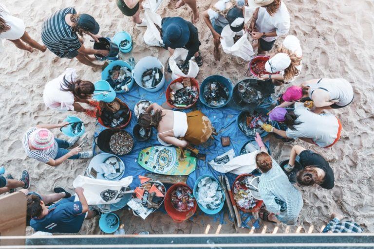 a group of people sitting around a table on a beach.
