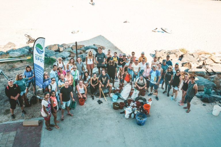 a group of people standing on top of a beach.