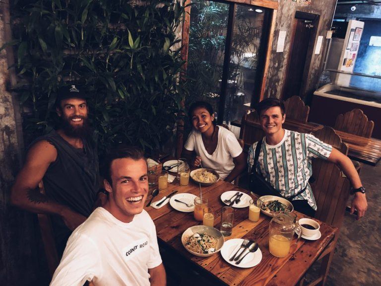 a group of people sitting at a table with plates of food.