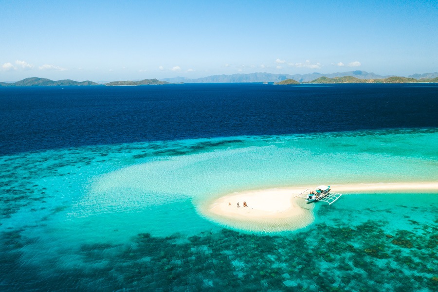 a small boat on a small island in the middle of the ocean.