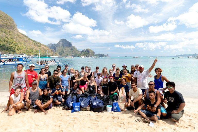 a group of people standing on top of a sandy beach.