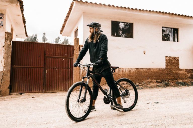 a man riding a bike down a dirt road.
