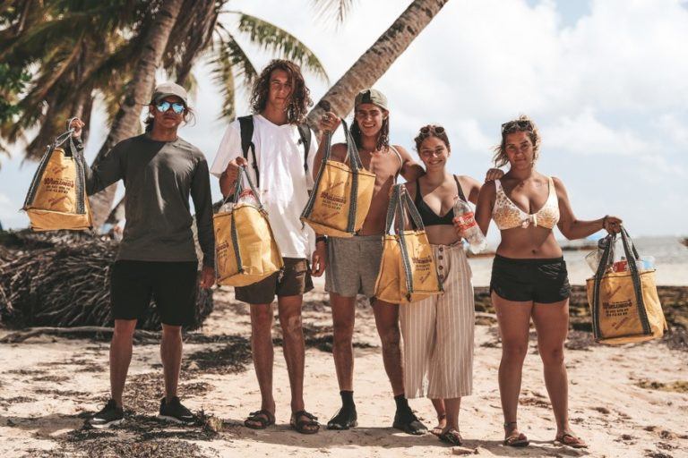 a group of people standing on top of a sandy beach.