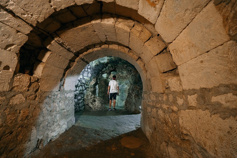 a man standing in a tunnel in a stone building.