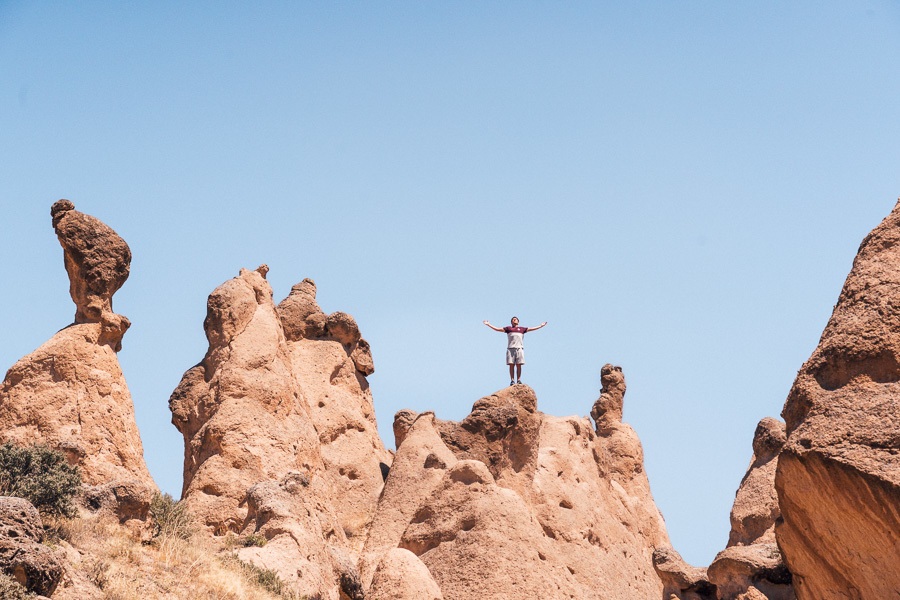 a man standing on top of a rock formation.