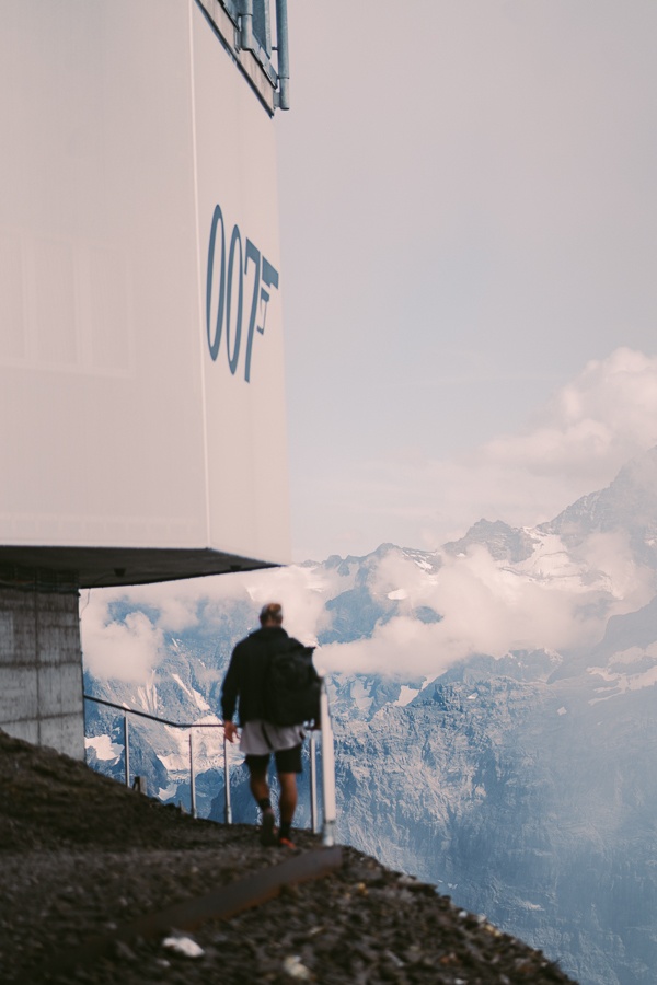 a man standing on top of a mountain next to a building.