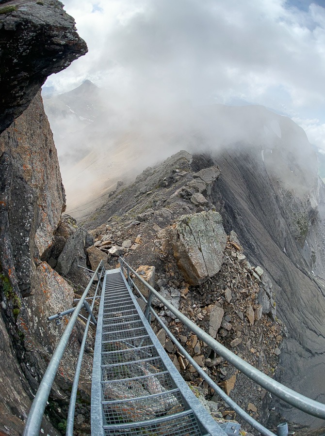 a long metal staircase going up a mountain.