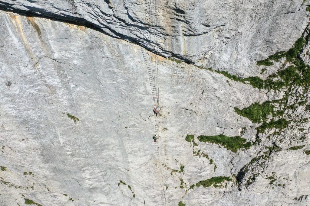 a person on a rock climbing up a cliff.