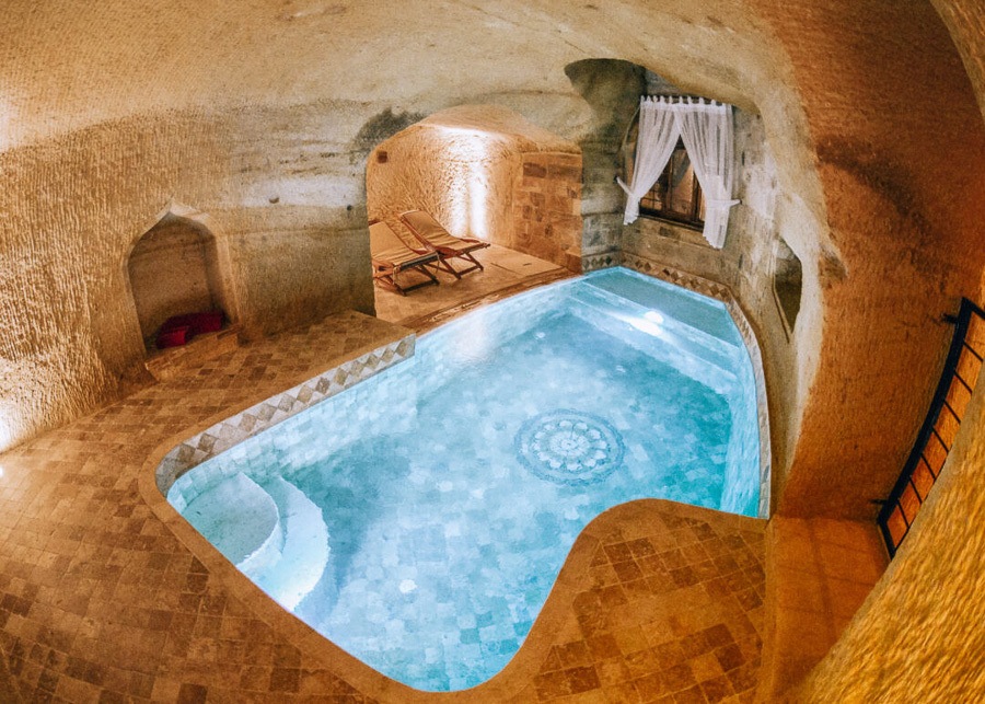 an indoor swimming pool in a cave like building.
