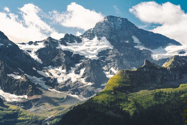 a mountain range with snow covered mountains in the background.
