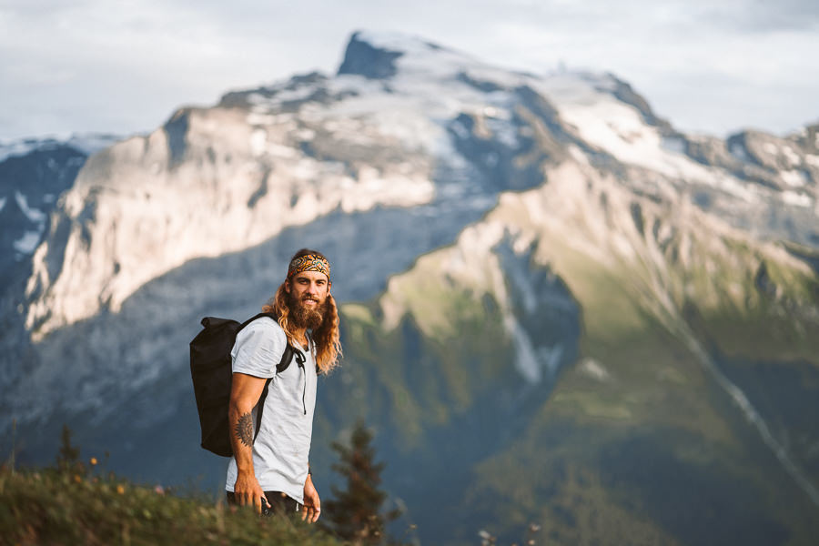 a man with a backpack standing on a mountain.