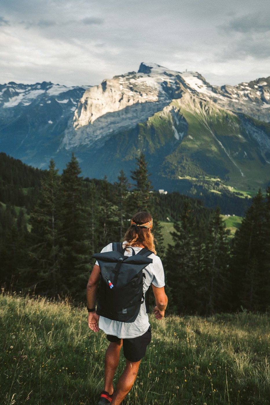 a man with a backpack walking in the mountains.