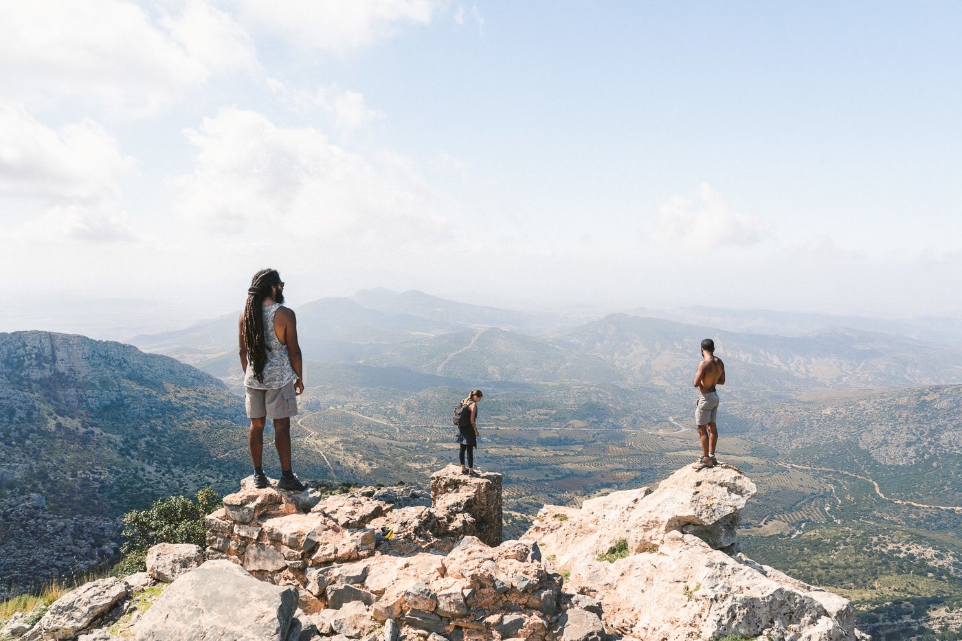 a group of people standing on top of a mountain.