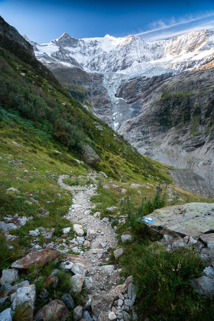 a rocky path leading to a glacier in the mountains.