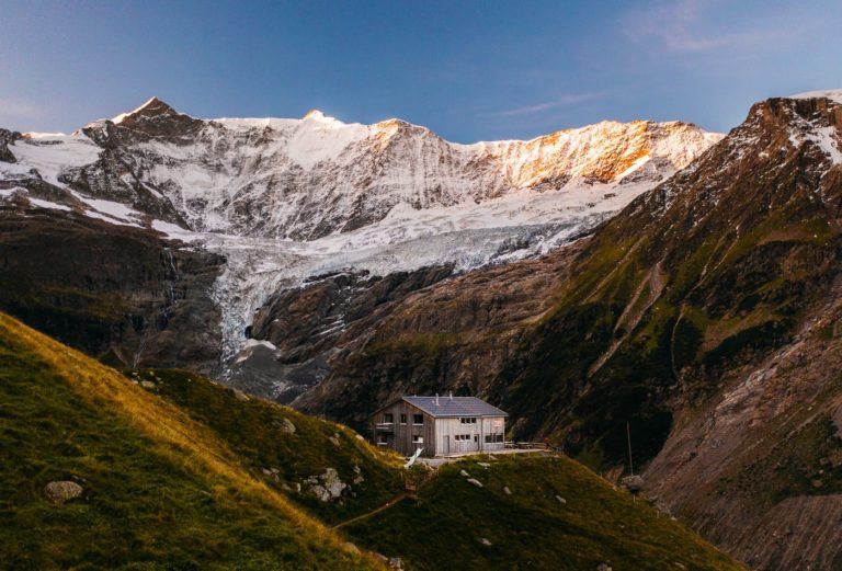 a house in the middle of the mountains.