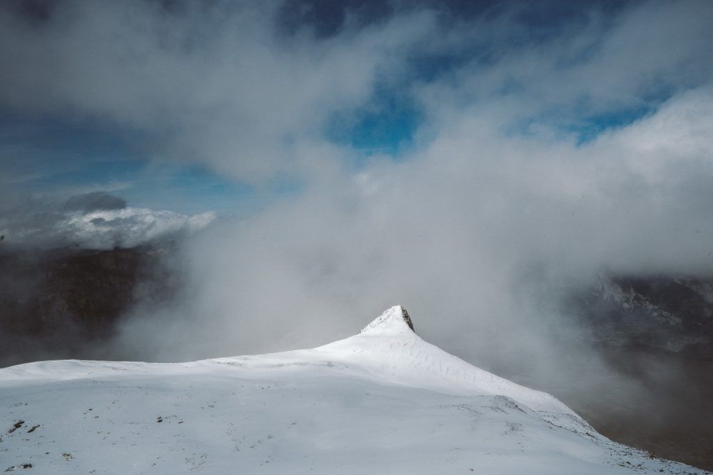a person standing on top of a snow covered mountain.