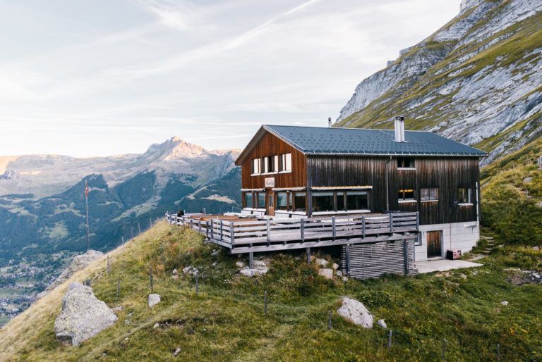 a house sitting on top of a green hillside.