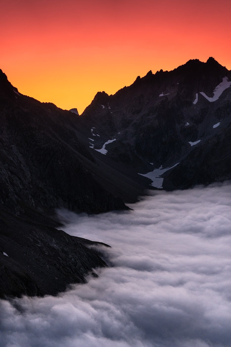 a view of a mountain range with a sunset in the background.