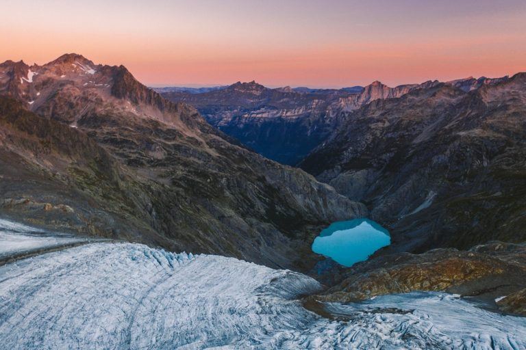 a blue lake in the middle of a mountain.