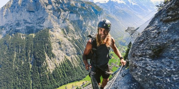 a man climbing up a steeple with a helmet on.