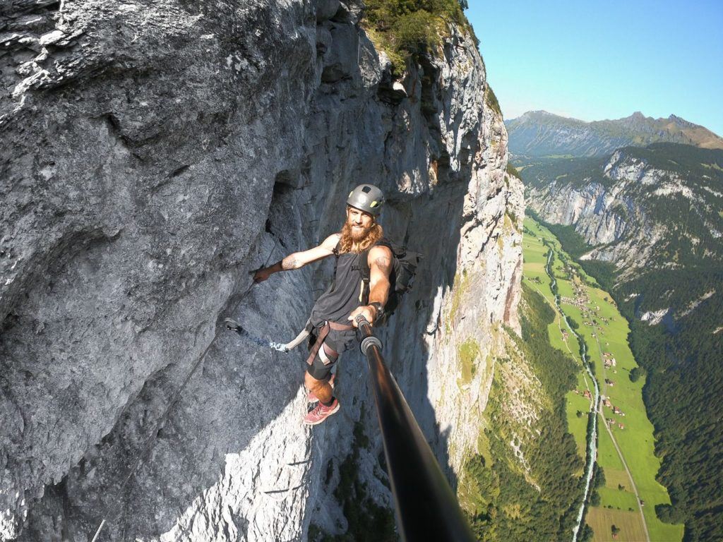 a man on a rock climbing on a ledge.