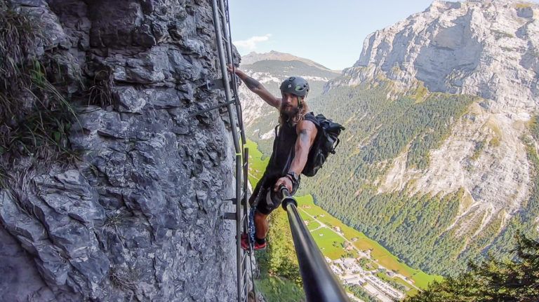 a man on a rock climbing up a steeple.