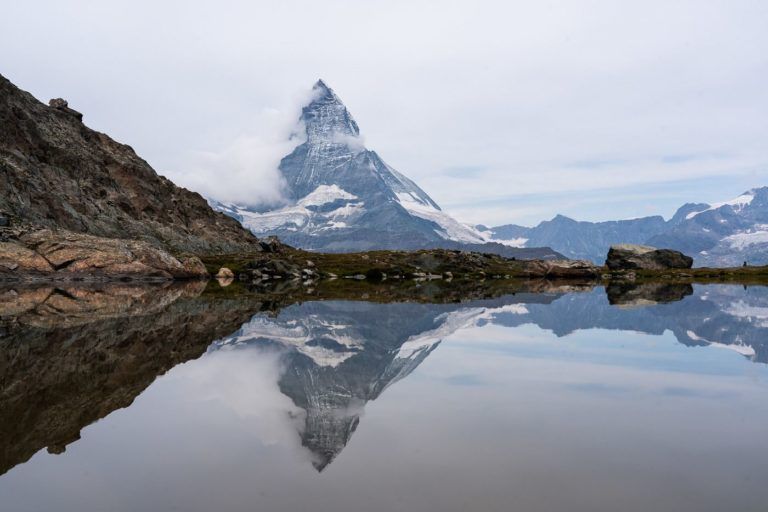 a mountain is reflected in the water of a lake.
