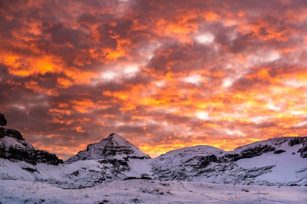 a snow covered mountain with a red sky in the background.