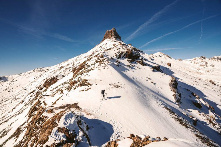 a person standing on top of a snow covered mountain.