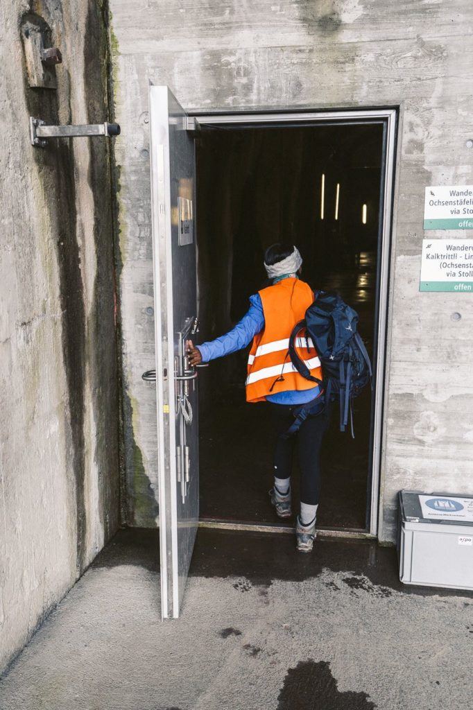 a person in an orange vest entering a building.