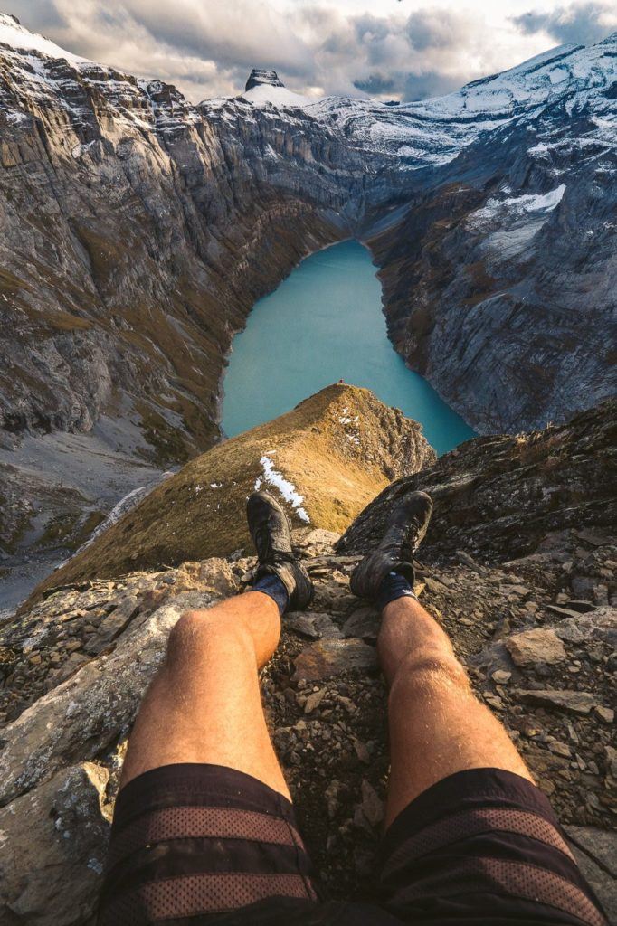 a person sitting on a rock with a view of a lake.