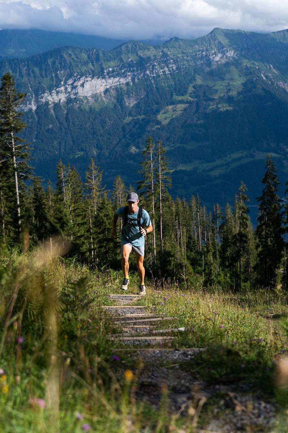 a man running on a trail in the mountains.