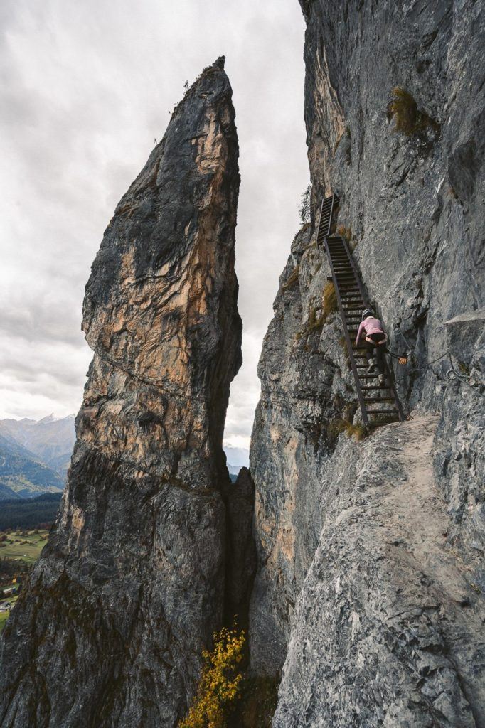 a person climbing up the side of a mountain.