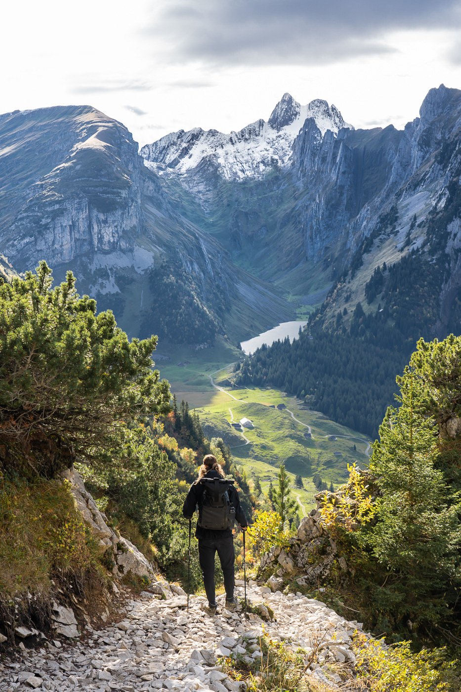 a person walking up a trail in the mountains.