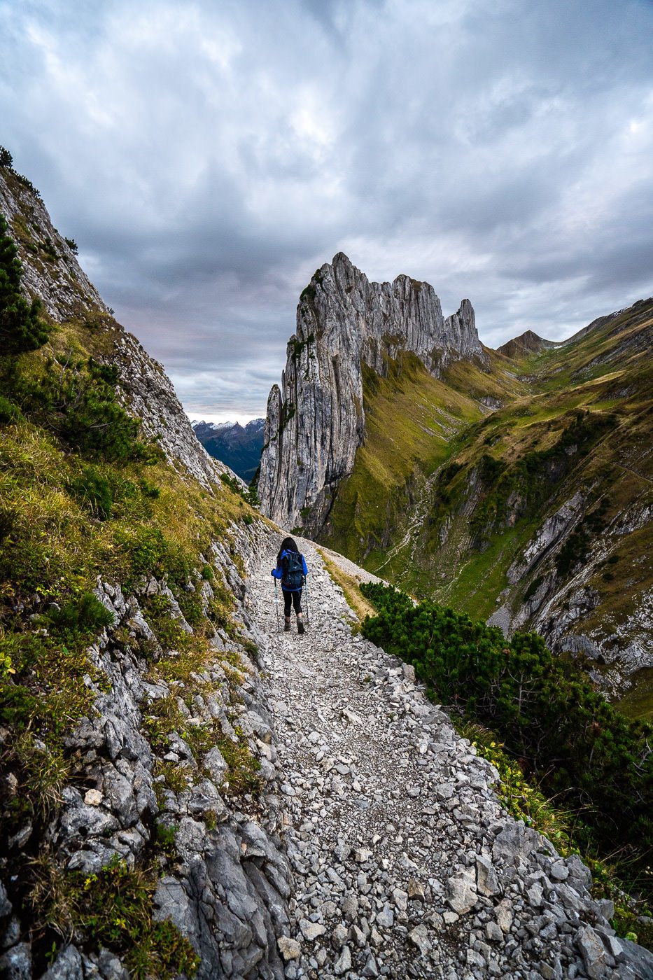 a person walking up a rocky path in the mountains.