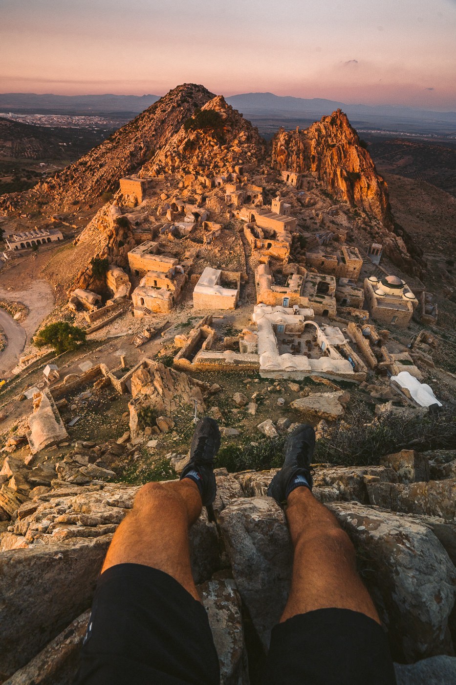 a person sitting on top of a rocky hill.